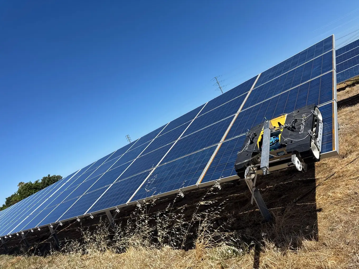 Robotic solar panel cleaner servicing a ground-mount array at a Pittsburg school district site