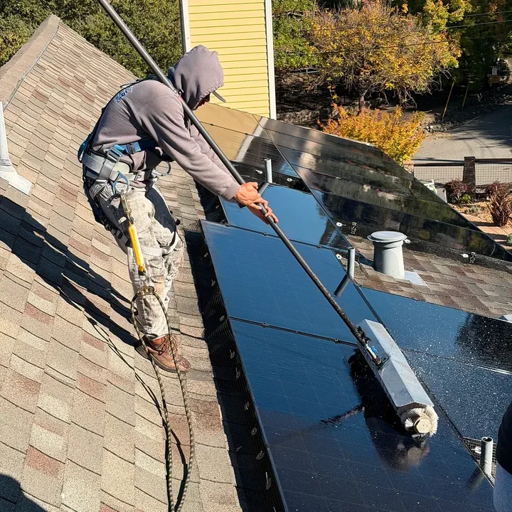 Total Solar Cleaning technician cleaning solar panels on a residential roof in Concord, CA